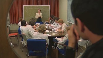 Movie still from “Alligator” (1980), directed by Lewis Teague – A group of people sitting around a table; Wide shot, Over the shoulder angle