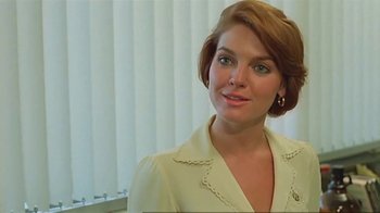 Movie still from “Alligator” (1980), directed by Lewis Teague – A woman in a white shirt is standing in front of a window; Close Up shot, Over the shoulder angle