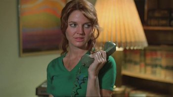 Movie still from “Alligator” (1980), directed by Lewis Teague – A woman in a green shirt holding a green telephone; Close Up shot, Low angle