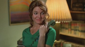 Movie still from “Alligator” (1980), directed by Lewis Teague – A woman in a green shirt is holding a phone up to her ear; Close Up shot, Low angle