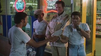 Movie still from “Alligator” (1980), directed by Lewis Teague – A group of men standing next to each other on the street; Medium shot, Low angle