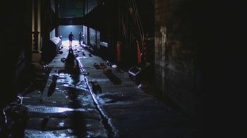 Movie still from “Alligator” (1980), directed by Lewis Teague – A person walking down a street in the dark; Extreme Wide shot, High angle
