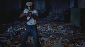 Movie still from “Alligator” (1980), directed by Lewis Teague – A man holding a camera in the middle of a pile of leaves; Medium shot, Low angle