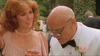 Movie still from “Alligator” (1980), directed by Lewis Teague – An older man in a tuxedo looking at a woman in a pink dress; Close Up shot, Low angle