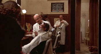 Movie still from “Amarcord” (1973), directed by Federico Fellini – Two men in white lab coats are getting their hair cut; Wide shot, Over the shoulder angle