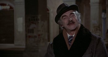 Movie still from “Amarcord” (1973), directed by Federico Fellini – An older man wearing a hat and smoking a cigarette; Close Up shot, Over the shoulder angle