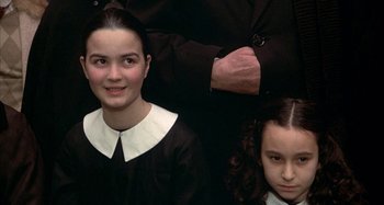 Movie still from “Amarcord” (1973), directed by Federico Fellini – Two young girls posing for a picture with an older man; Close Up shot, High angle