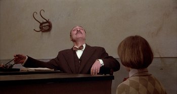 Movie still from “Amarcord” (1973), directed by Federico Fellini – A man sitting at a piano with his eyes wide open; Medium shot, Low angle