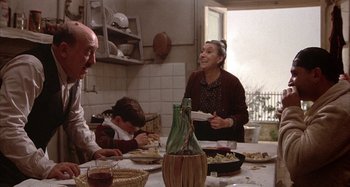 Movie still from “Amarcord” (1973), directed by Federico Fellini – An older woman and a young boy sitting at a dinner table; Medium shot, High angle
