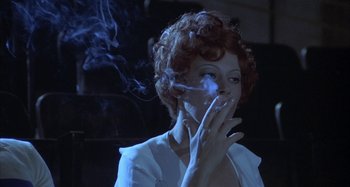 Movie still from “Amarcord” (1973), directed by Federico Fellini – A woman smoking a cigarette in a dark room; Close Up shot, Low angle