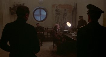 Movie still from “Amarcord” (1973), directed by Federico Fellini – A group of people sitting around a table; Wide shot, Over the shoulder angle
