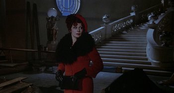 Movie still from “Amarcord” (1973), directed by Federico Fellini – A woman in a red coat holding a black purse; Medium shot, Low angle