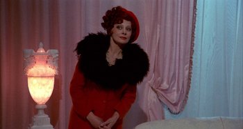 Movie still from “Amarcord” (1973), directed by Federico Fellini – An older woman wearing a red coat and a red hat; Medium shot, Over the shoulder angle