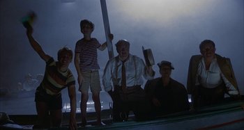 Movie still from “Amarcord” (1973), directed by Federico Fellini – A group of people standing next to each other on a dock; Wide shot, Low angle