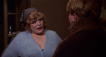 Movie still from “Amarcord” (1973), directed by Federico Fellini – A woman in a blue sweater talking to a man in a brown jacket; Close Up shot, Over the shoulder angle