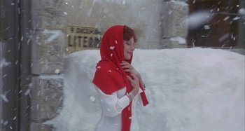 Movie still from “Amarcord” (1973), directed by Federico Fellini – A woman wearing a red scarf standing in the snow; Medium shot, Low angle