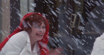 Movie still from “Amarcord” (1973), directed by Federico Fellini – A woman with a red scarf on her head laughing in the snow; Close Up shot, High angle