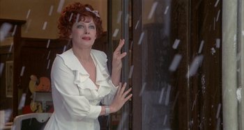 Movie still from “Amarcord” (1973), directed by Federico Fellini – A woman in a white shirt is looking out a window; Close Up shot, Low angle