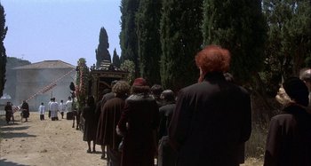 Movie still from “Amarcord” (1973), directed by Federico Fellini – A group of people walking down a street; Wide shot, High angle