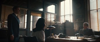 Movie still from “American Pastoral” (2016), directed by Ewan McGregor – A woman sitting at a table in front of a window; Wide shot, Over the shoulder angle