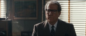 Movie still from “American Pastoral” (2016), directed by Ewan McGregor – An older man wearing a suit and tie; Close Up shot, Over the shoulder angle