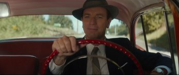 Movie still from “American Pastoral” (2016), directed by Ewan McGregor – A man wearing a hat sitting in the driver's seat of a car; Close Up shot, Low angle