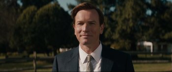 Movie still from “American Pastoral” (2016), directed by Ewan McGregor – A person wearing a suit and tie; Close Up shot, Over the shoulder angle