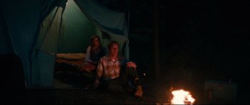Movie still from “American Pastoral” (2016), directed by Ewan McGregor – A man and a woman sitting on the ground near a fire; Wide shot, High angle