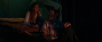 Movie still from “American Pastoral” (2016), directed by Ewan McGregor – A man and a little girl sitting on a couch; Medium shot, Low angle