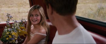 Movie still from “American Pastoral” (2016), directed by Ewan McGregor – A young girl smiles at a man in a white shirt; Close Up shot, Over the shoulder angle