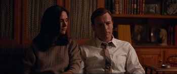 Movie still from “American Pastoral” (2016), directed by Ewan McGregor – A man and a woman sitting next to each other in a room; Medium shot, High angle