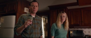 Movie still from “American Pastoral” (2016), directed by Ewan McGregor – A man and a woman standing next to each other in a room; Medium shot, Over the shoulder angle