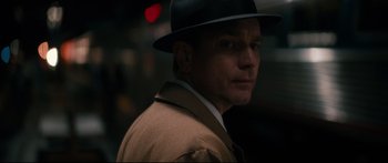 Movie still from “American Pastoral” (2016), directed by Ewan McGregor – A person wearing a suit and a hat; Close Up shot, Over the shoulder angle