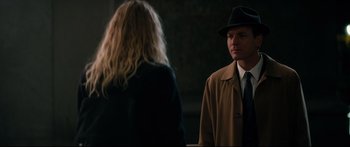 Movie still from “American Pastoral” (2016), directed by Ewan McGregor – A man in a hat and a woman in a black dress; Medium shot, Over the shoulder angle