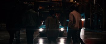 Movie still from “American Pastoral” (2016), directed by Ewan McGregor – A group of people crossing a street at night; Wide shot, High angle