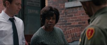 Movie still from “American Pastoral” (2016), directed by Ewan McGregor – An older black woman standing in front of a brick wall; Medium shot, Over the shoulder angle