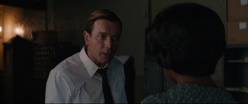 Movie still from “American Pastoral” (2016), directed by Ewan McGregor – A man wearing a white dress shirt and a black tie; Medium shot, Over the shoulder angle