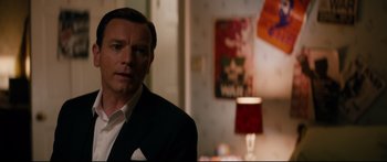 Movie still from “American Pastoral” (2016), directed by Ewan McGregor – A man wearing a suit and tie standing in a room; Close Up shot, Over the shoulder angle