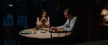 Movie still from “American Pastoral” (2016), directed by Ewan McGregor – A man and a woman sitting at a dinner table; Medium shot, High angle