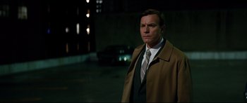 Movie still from “American Pastoral” (2016), directed by Ewan McGregor – A man wearing a suit and tie standing in a parking lot; Medium shot, Over the shoulder angle