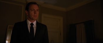 Movie still from “American Pastoral” (2016), directed by Ewan McGregor – A man in a suit and tie standing in a room; Close Up shot, Low angle