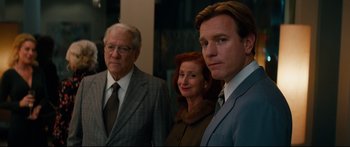 Movie still from “American Pastoral” (2016), directed by Ewan McGregor – Two men and a woman standing next to each other; Medium shot, Over the shoulder angle