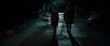 Movie still from “American Pastoral” (2016), directed by Ewan McGregor – A man and a woman walking down a street at night; Wide shot, High angle