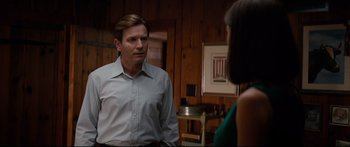 Movie still from “American Pastoral” (2016), directed by Ewan McGregor – A man and a woman are standing in a living room; Medium shot, Over the shoulder angle