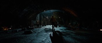 Movie still from “American Pastoral” (2016), directed by Ewan McGregor – A man walking down a dark street holding a guitar case; Wide shot, High angle