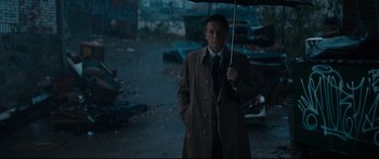 Movie still from “American Pastoral” (2016), directed by Ewan McGregor – A man holding an umbrella in the rain; Wide shot, Low angle