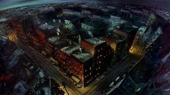 Movie still from “American Pop” (1981), directed by Ralph Bakshi – An aerial view of a city at night with buildings lit up at night; Extreme Wide shot, Overhead angle