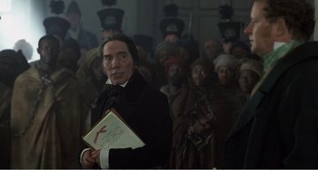 Movie still from “Amistad” (1997), directed by Steven Spielberg – A group of people standing in front of a building; Medium shot, Over the shoulder angle