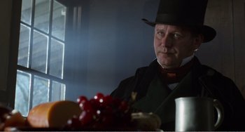 Movie still from “Amistad” (1997), directed by Steven Spielberg – A man wearing a top hat sitting in front of a bowl of fruit; Close Up shot, Over the shoulder angle