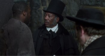 Movie still from “Amistad” (1997), directed by Steven Spielberg – A man wearing a top hat and a long coat; Close Up shot, Over the shoulder angle